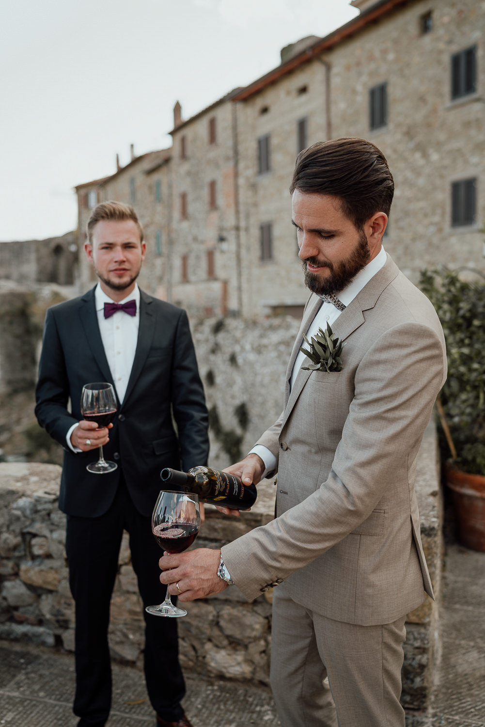 amsterdam wedding photography groom pours wine in tuscany at destination wedding