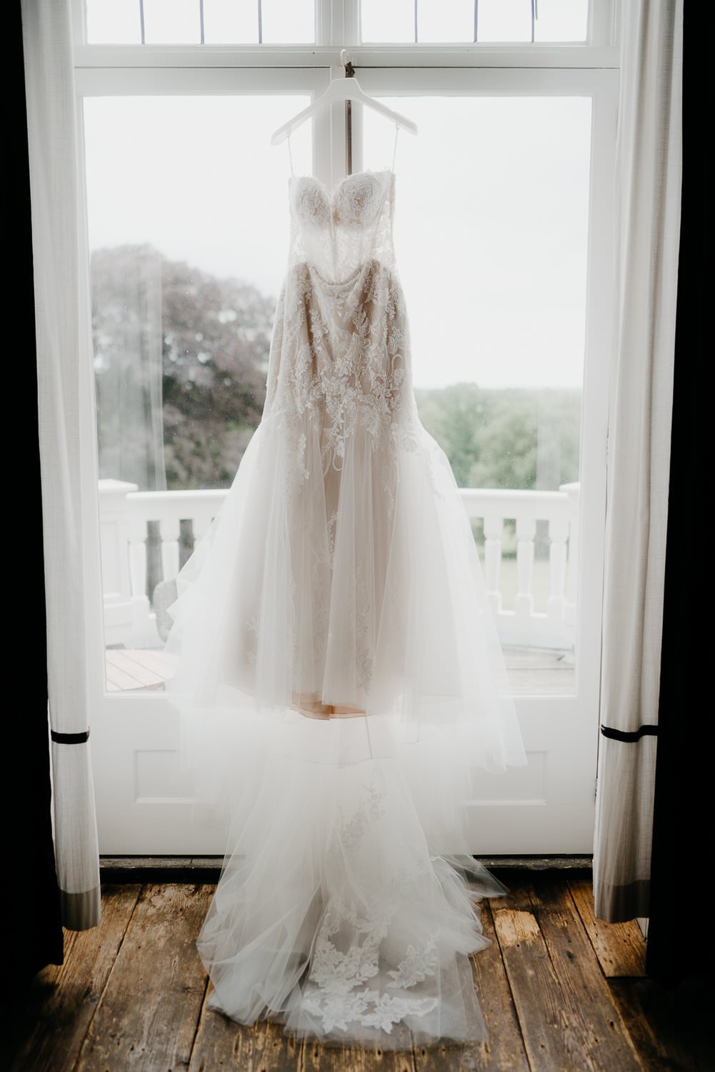 Michelle Jethro-041 - elegant white wedding dress hanging in a window in amsterdam.jpg