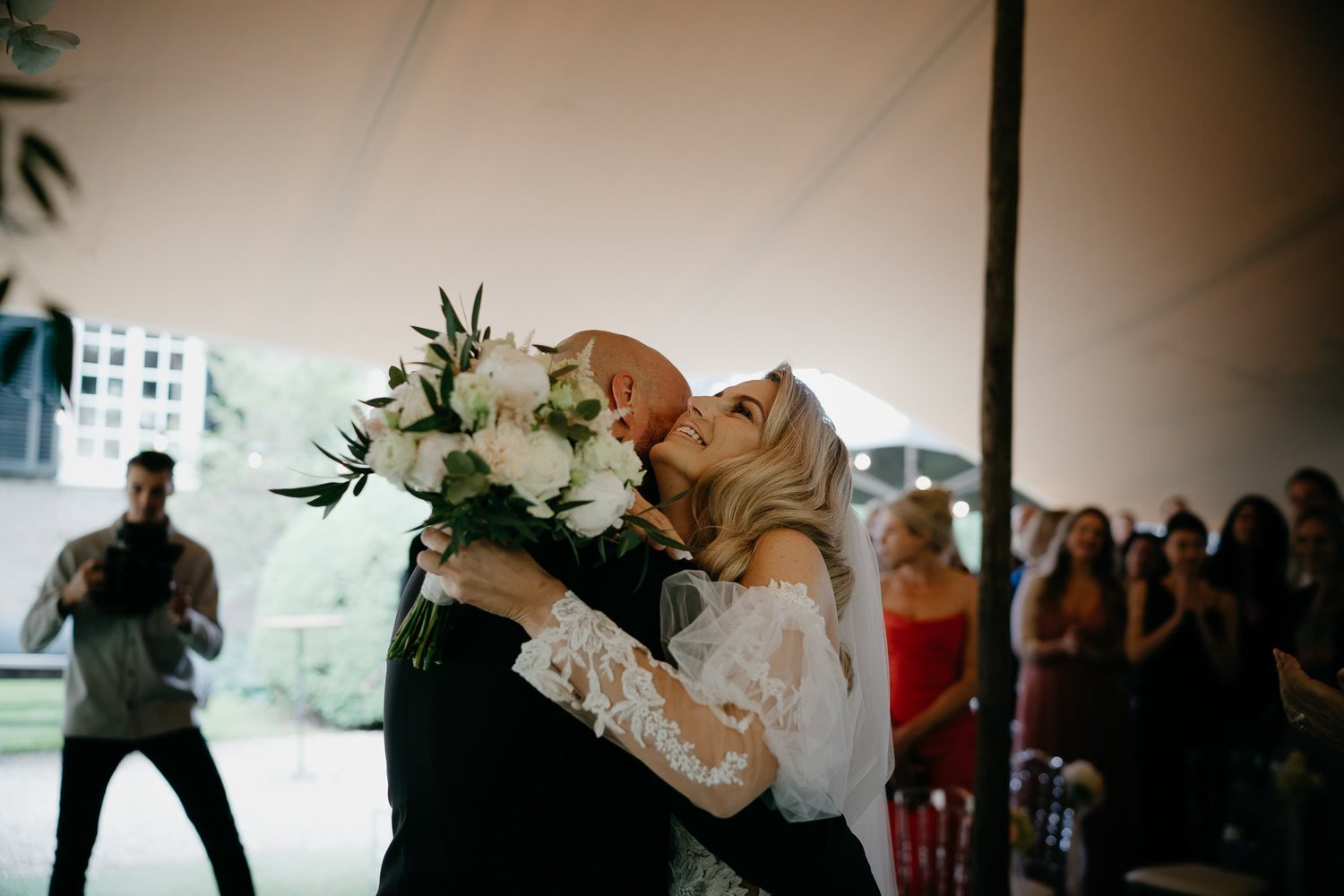 Michelle Jethro-077 - bride embracing groom at wedding reception, photographer capturing the moment.jpg