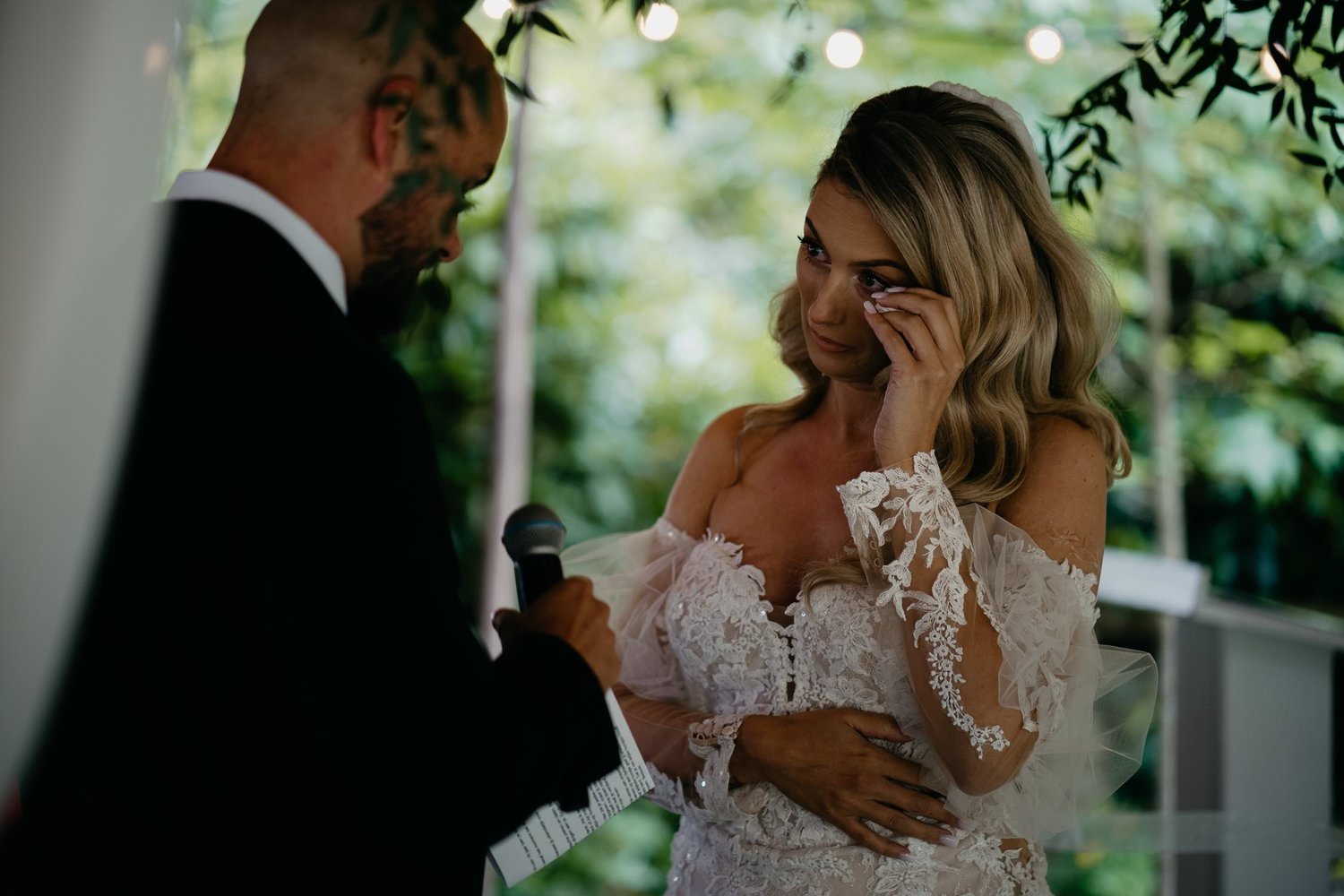 Michelle Jethro-113 - emotional bride crying during wedding ceremony while groom speaks into microphone.jpg