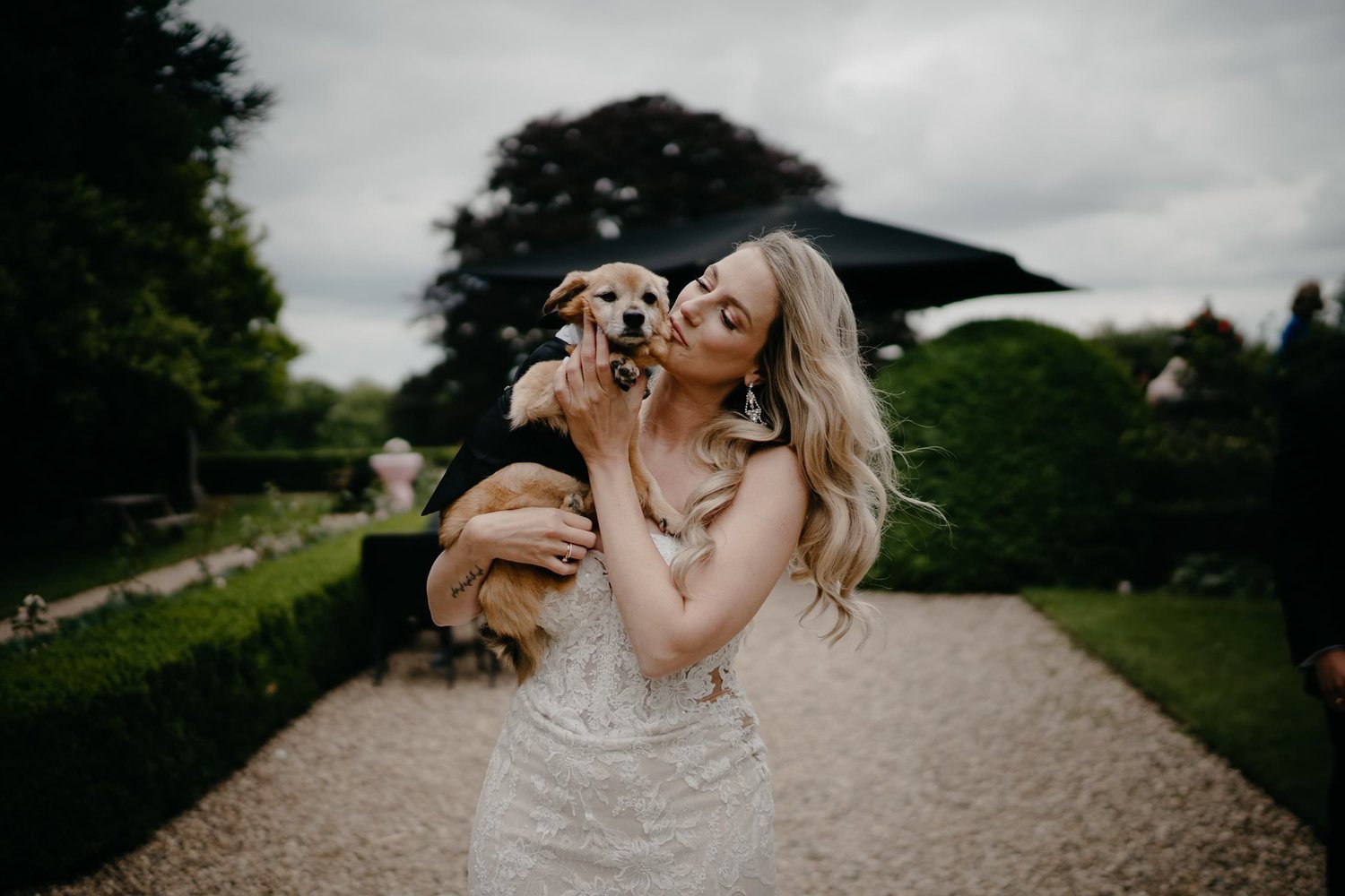 Michelle Jethro-168 - bride holding adorable dog wearing tuxedo at wedding reception.jpg
