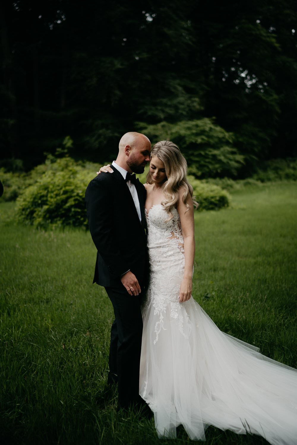 Michelle Jethro-195 - groom embracing bride wearing mermaid wedding dress in green park.jpg