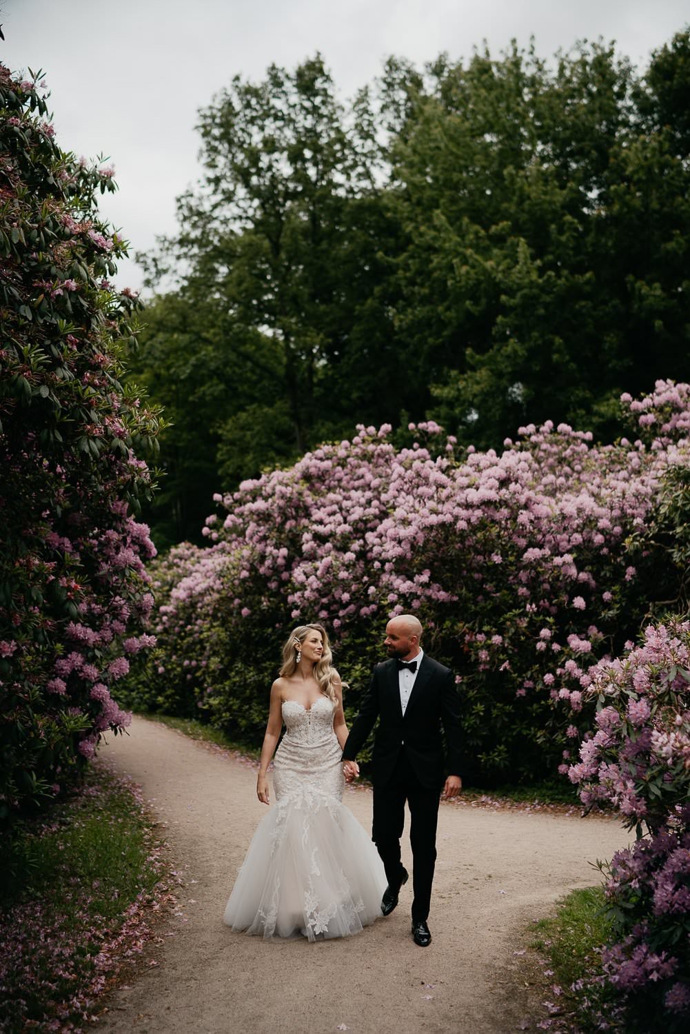 Michelle Jethro-209 - bride and groom walking in blooming park holding hands after wedding ceremony.jpg