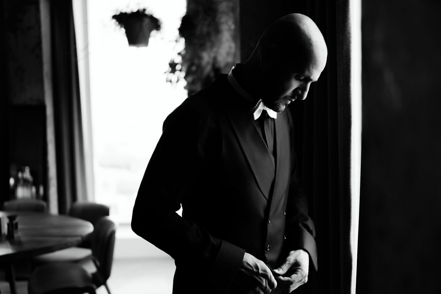 Kareline_Amir_009_2 - Elegant groom buttoning jacket in amsterdam loft before wedding photoshoot.jpg