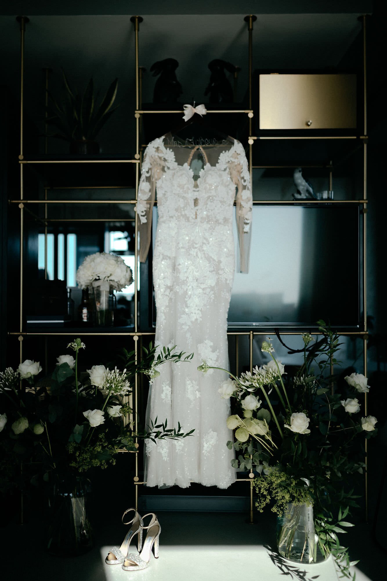 Kareline_Amir_047 - Elegant wedding dress hanging in modern loft with bridal bouquet and shoes.jpg
