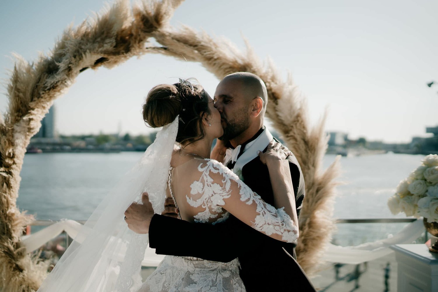 Kareline_Amir_155 - Bride and groom kissing at wedding ceremony on a terrace overlooking amsterdam's ij river.jpg