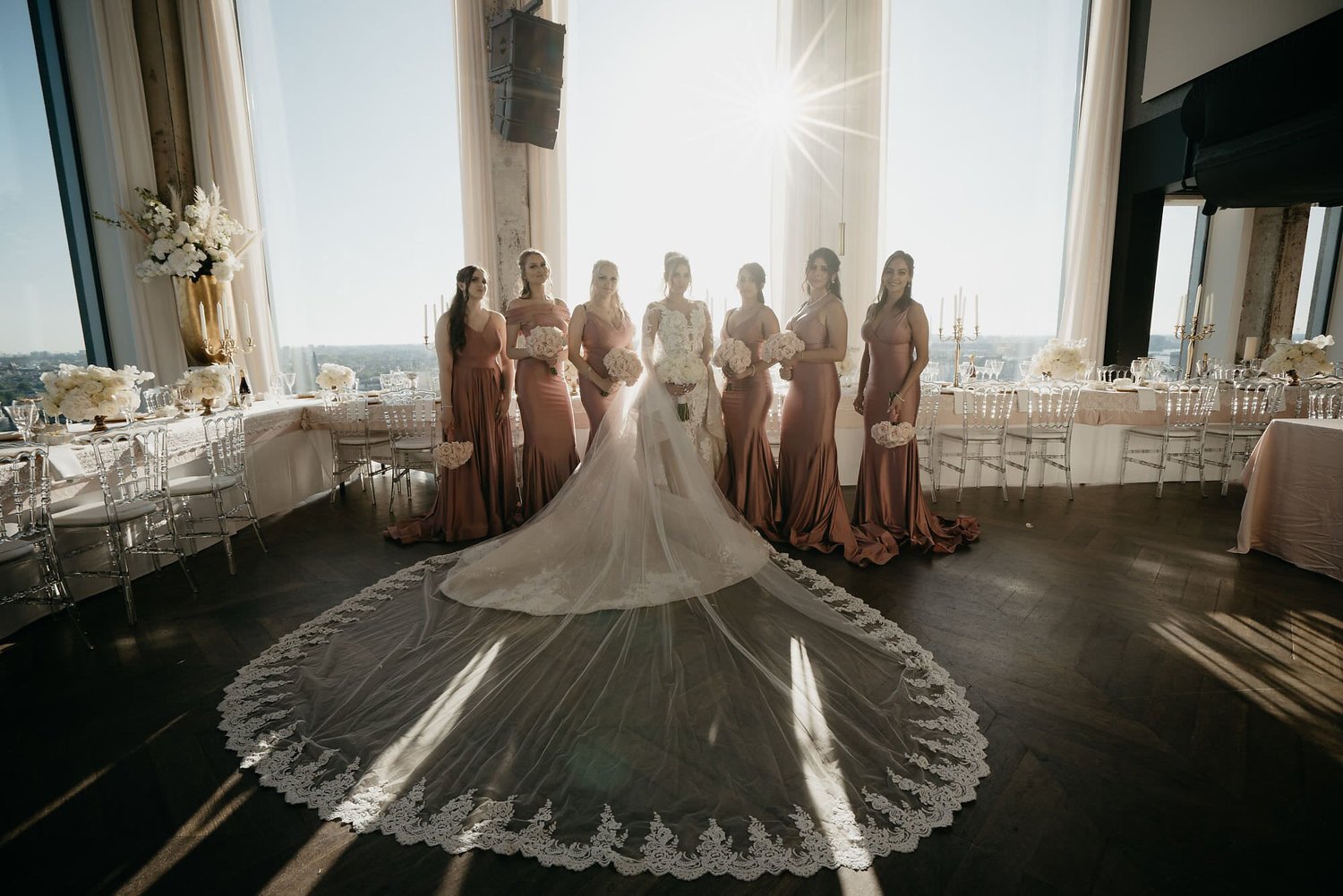 Kareline_Amir_199 - Bride posing with bridesmaids in a loft in amsterdam, showing her long bridal veil.jpg