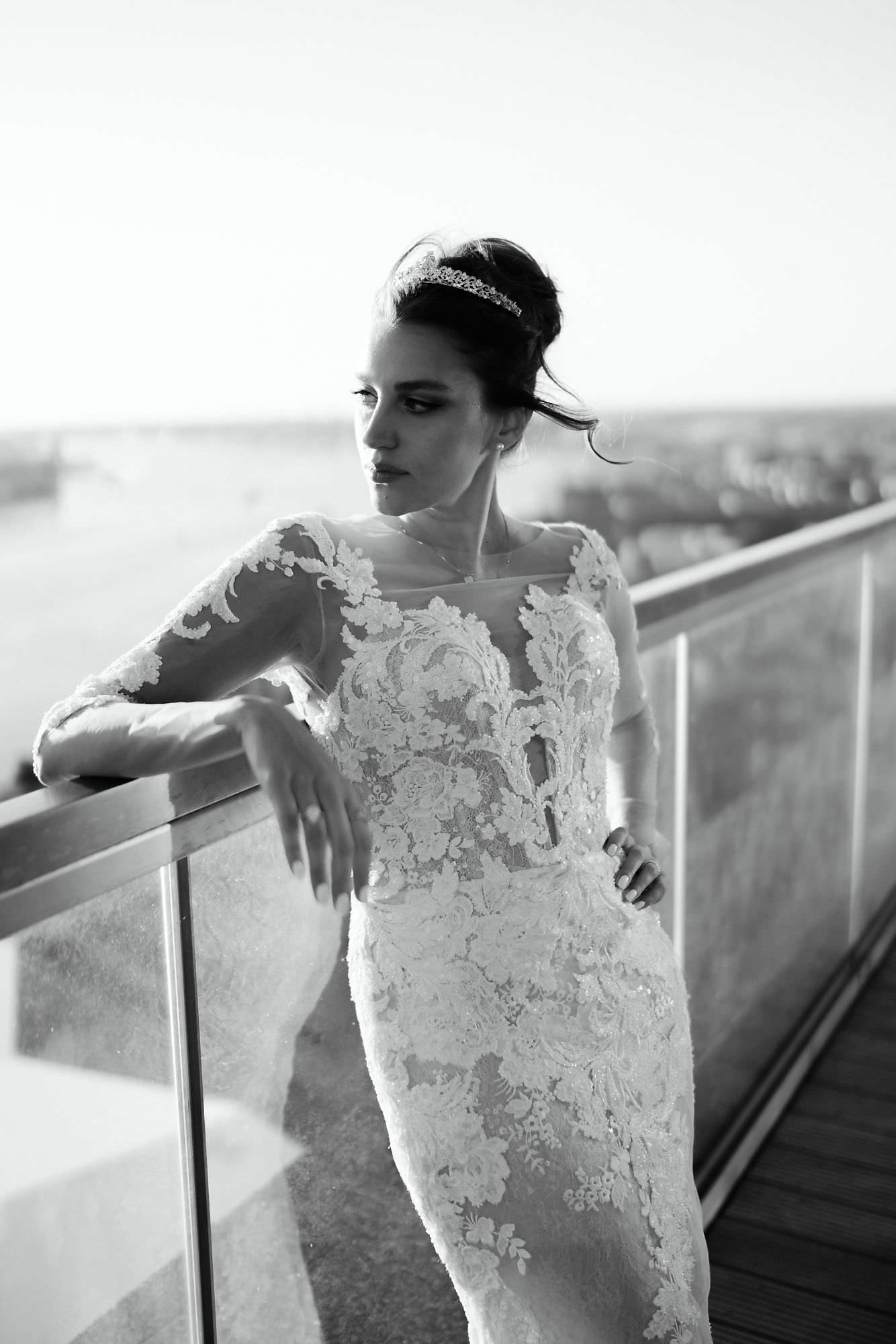 Kareline_Amir_316_2 - Bride wearing elegant white dress posing on balcony overlooking amsterdam cityscape during photoshoot.jpg